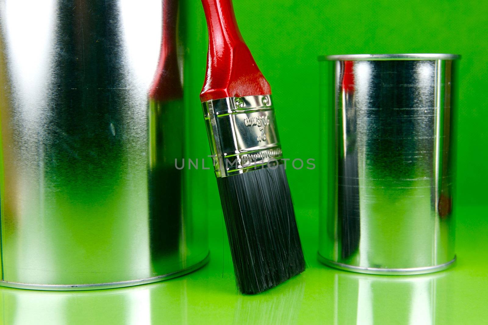 Paints and brushes isolated against a green background