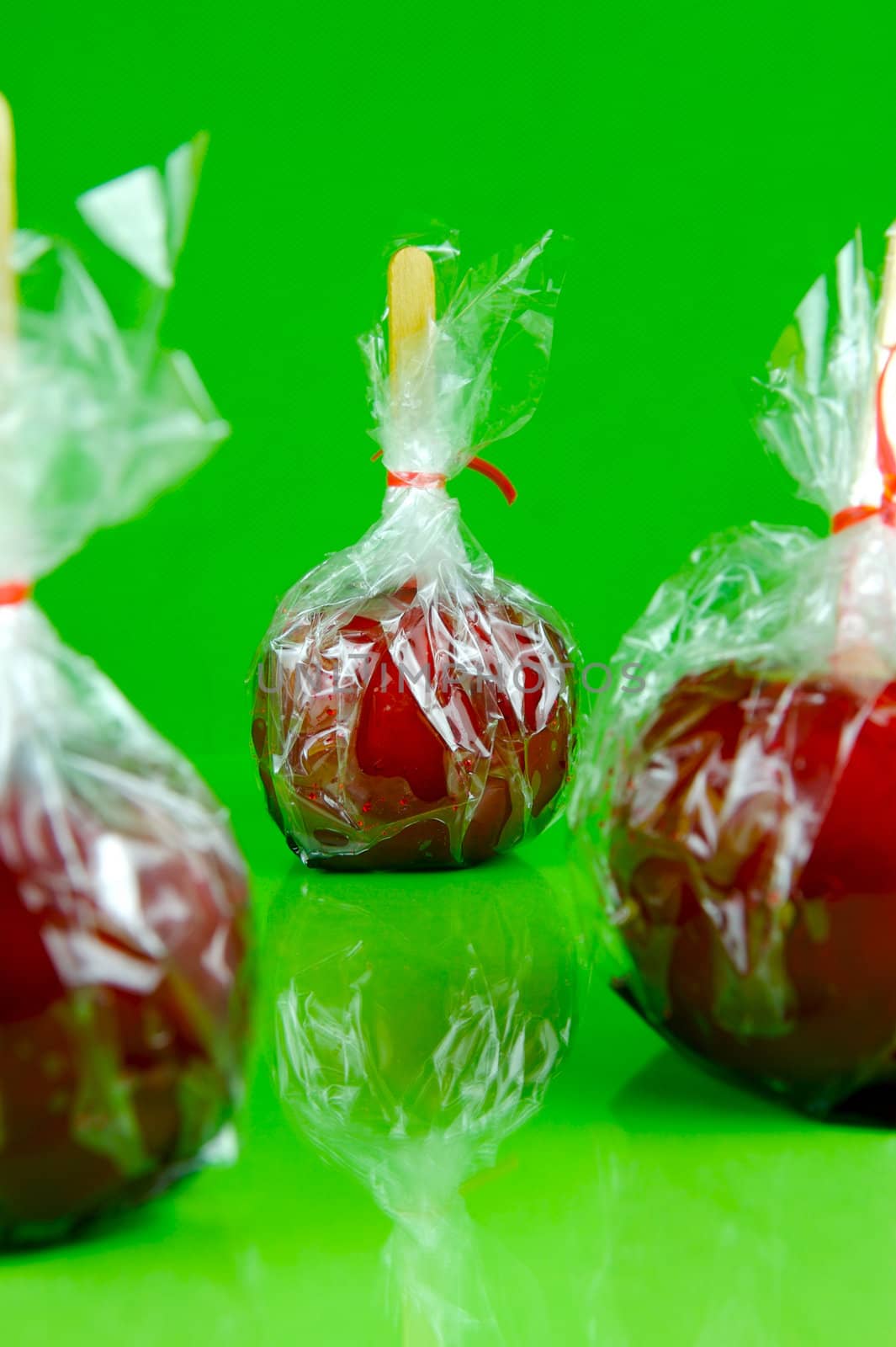 Candy apples isolated against a green background