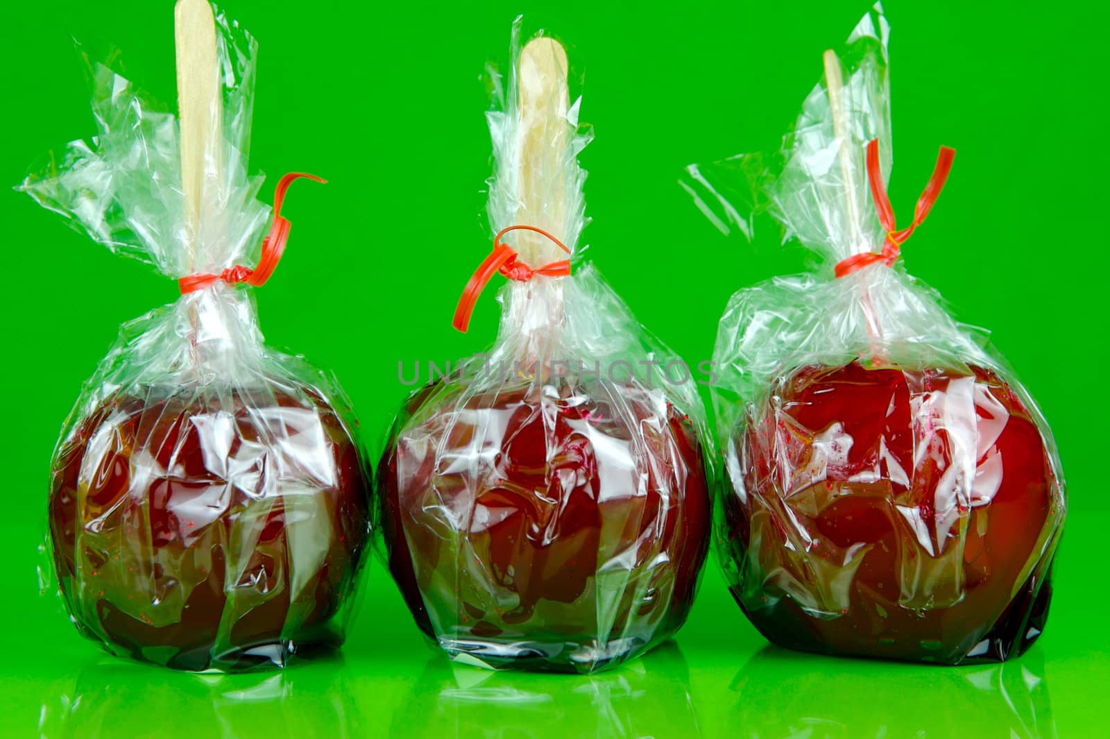 Candy apples isolated against a green background