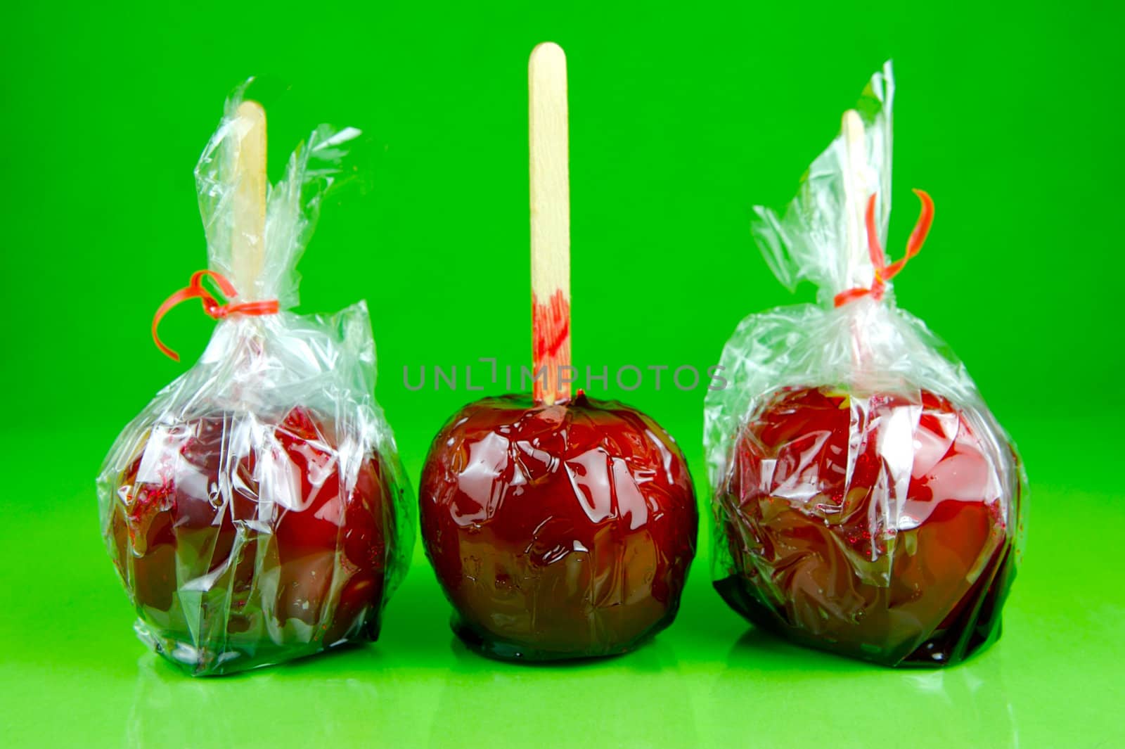 Candy apples isolated against a green background