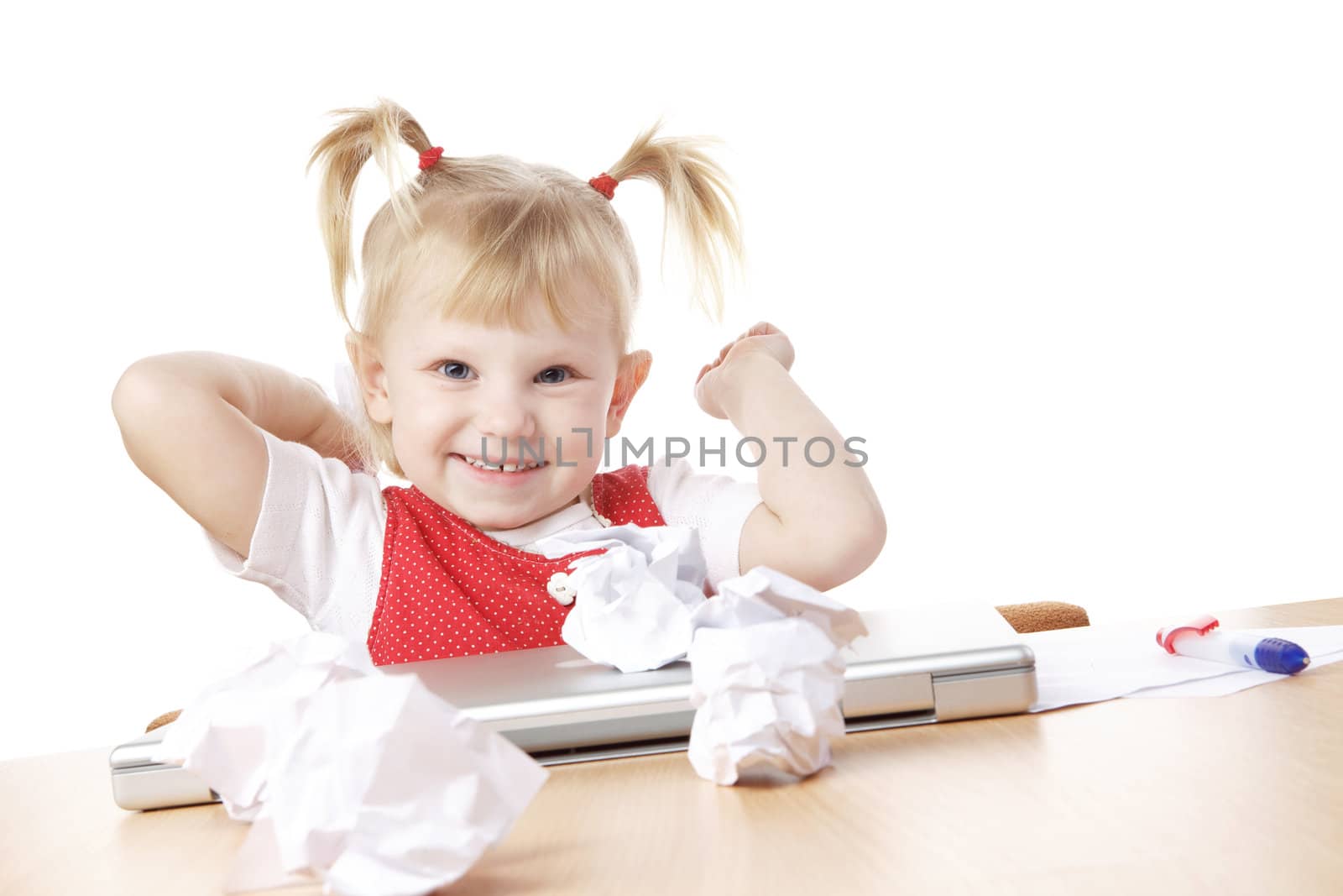 child throwing crampled sheets of paper at the table