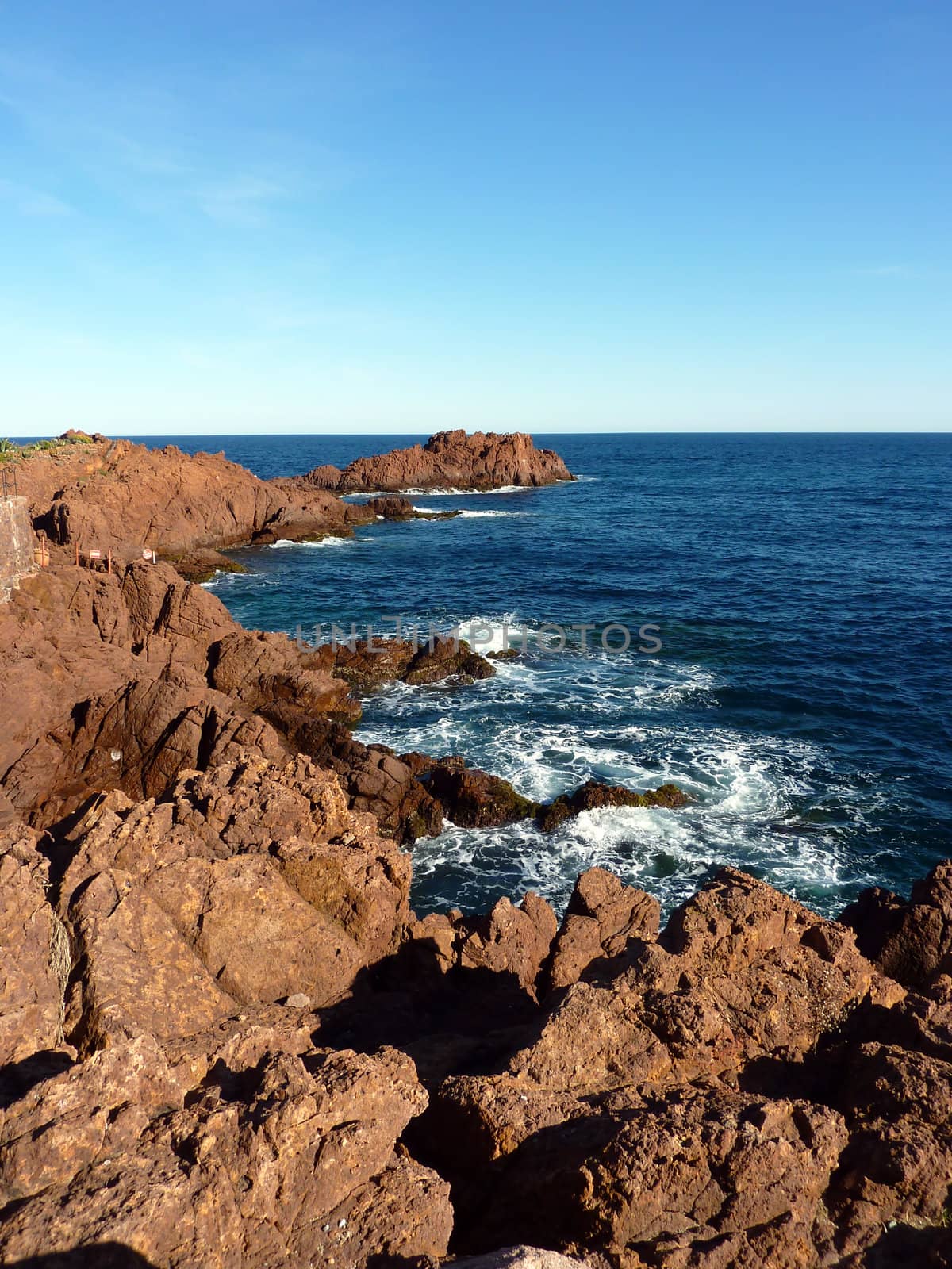 Red rocks of cliffs and mediterranean sea at Esterel massif, south of France, by beautiful weather