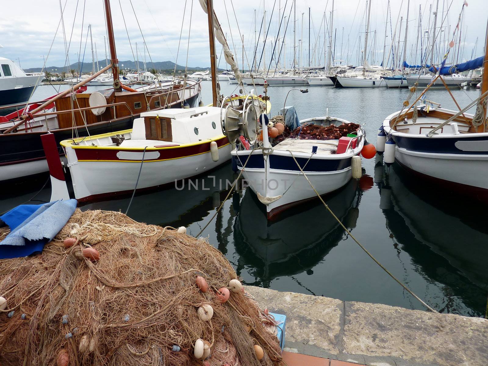 Colored fishing boats at Sanary-sur-mer harbor with a big fishing net in front of them, France