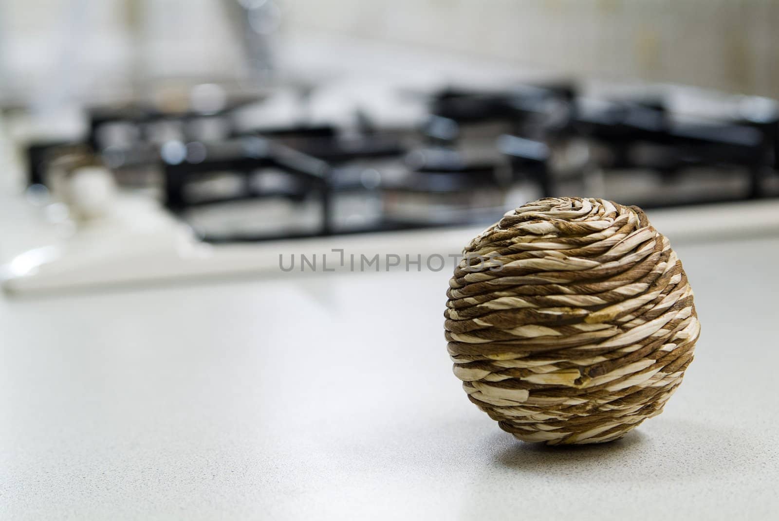 Straw sphere on the kitchen table near gas stove by palomnik