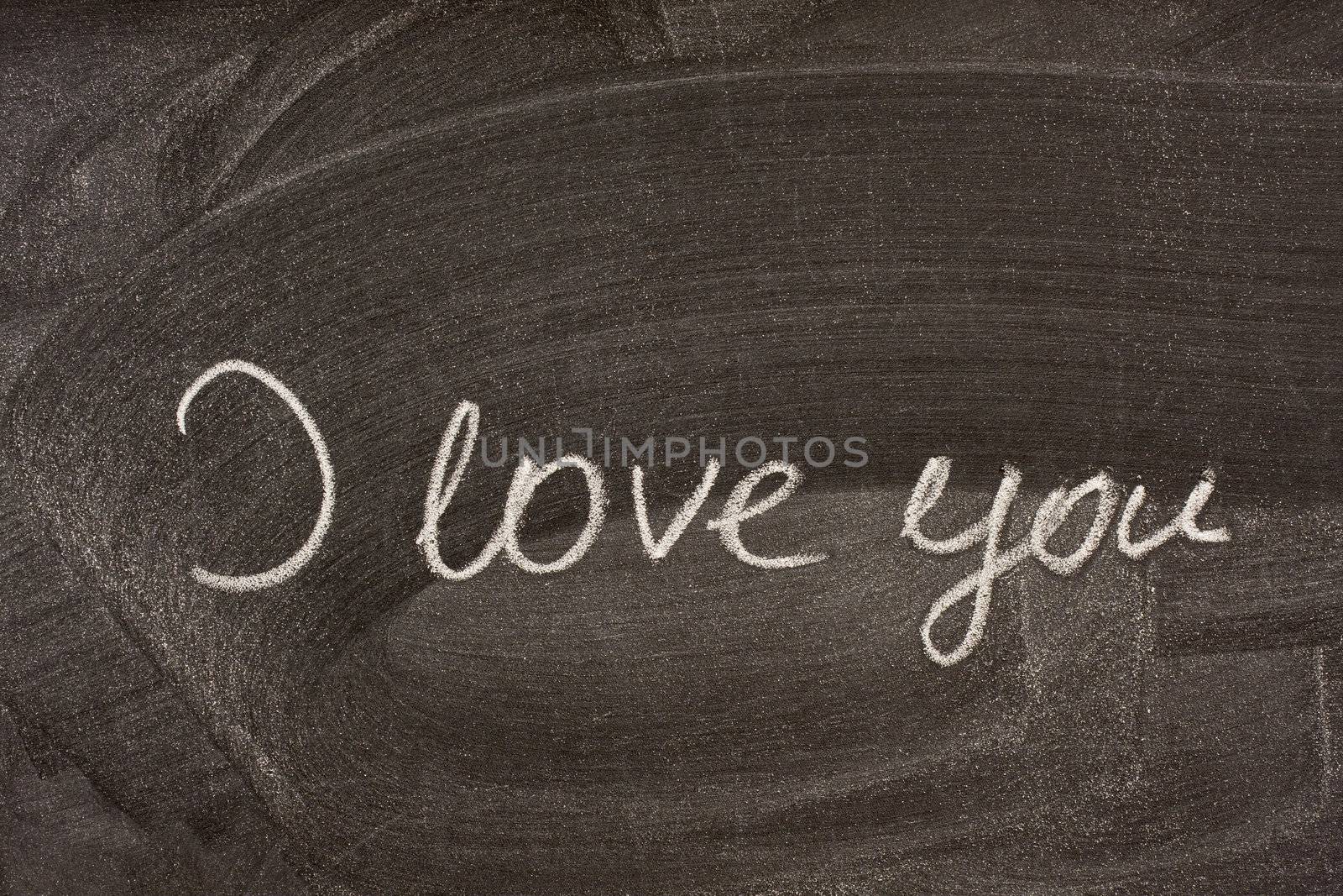 I love you handwritten with white chalk on school blackboard with strong smudge patterns from eraser