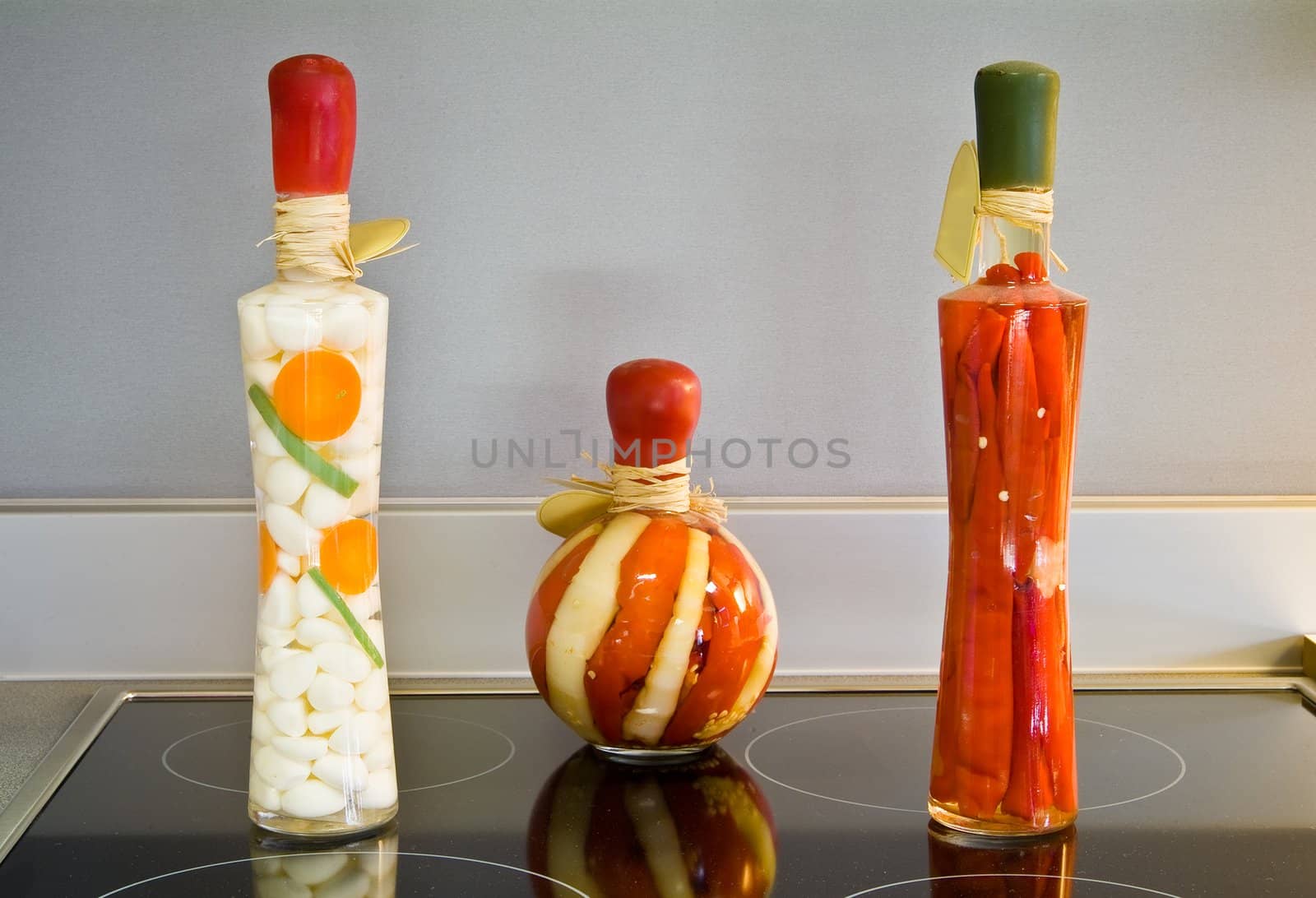 Decorative bottles on the black ceramic surface on the kitchen