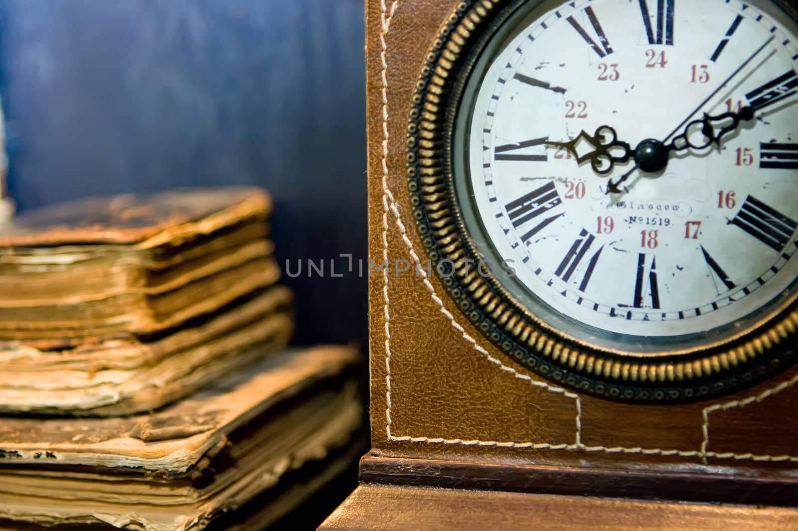 Old books and old clock with leather cover