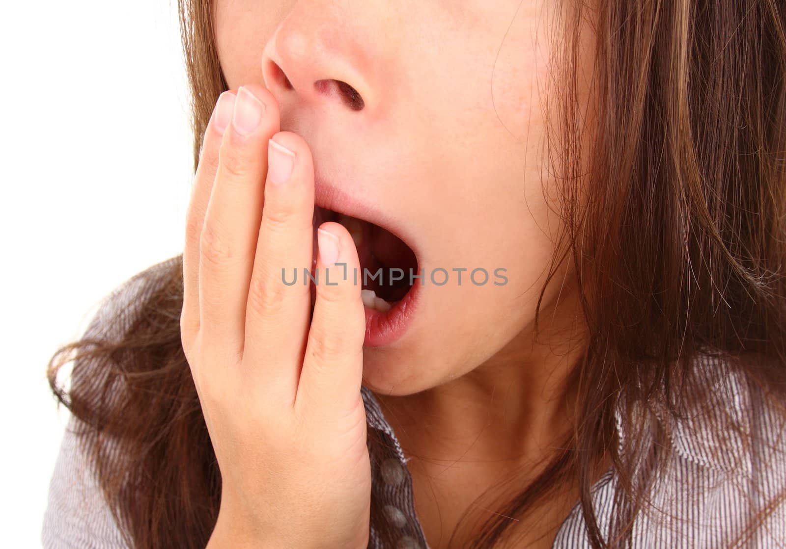 Tired woman yawning holding her hand in front of the mouth.