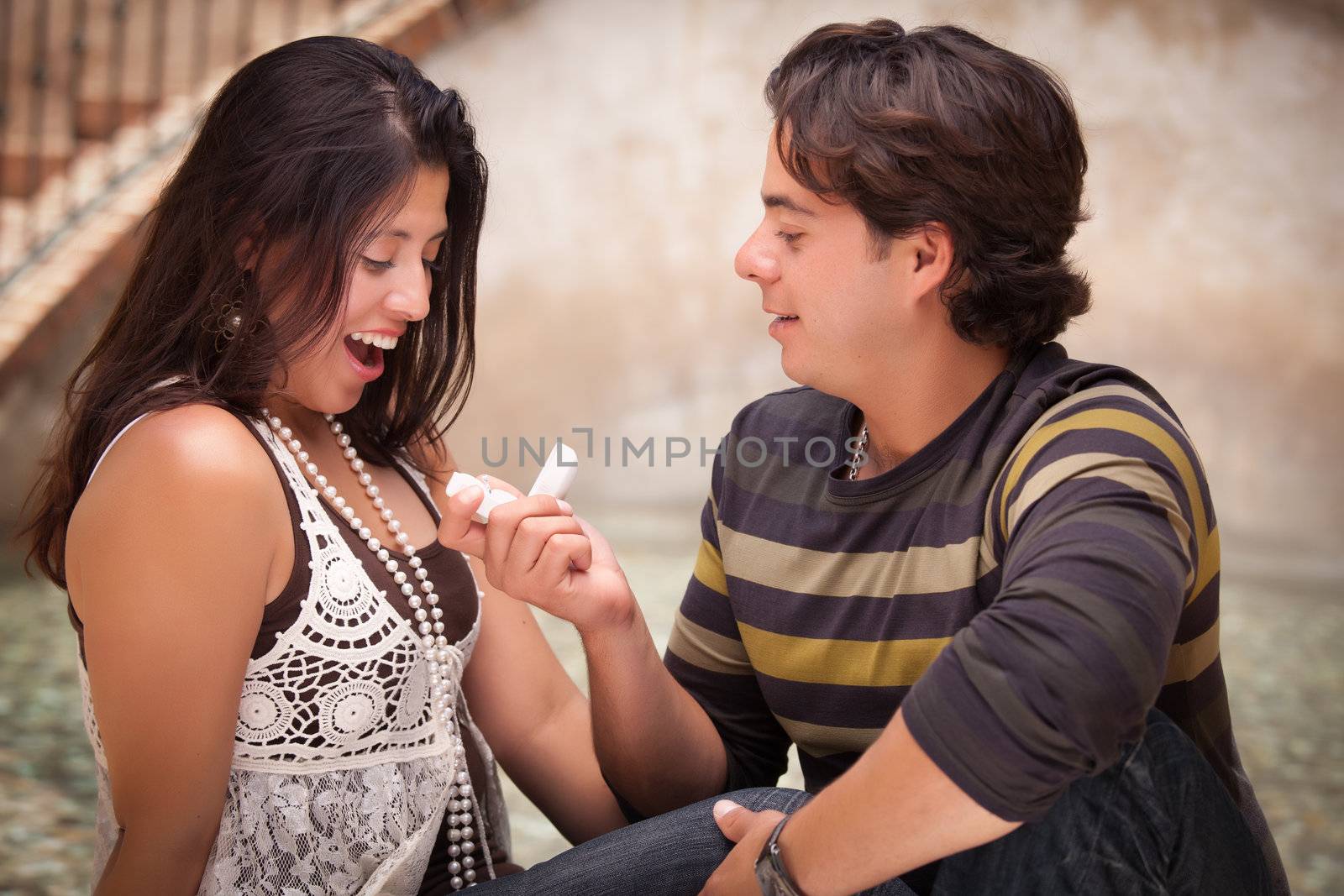 Hispanic Man Proposing with an Engagement Ring to His Love.