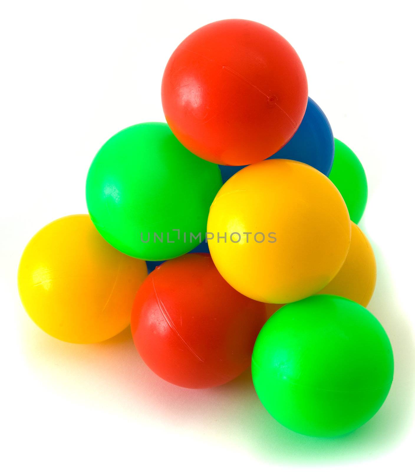 Pyramid from small plastic colored balls on the white background