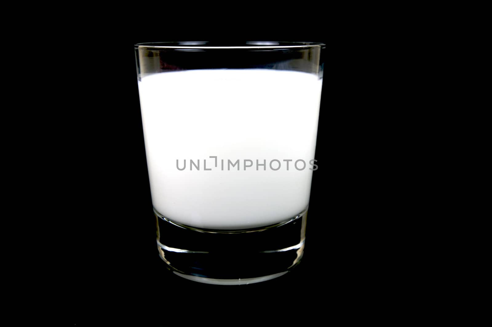 A glass of milk isolated against a black background