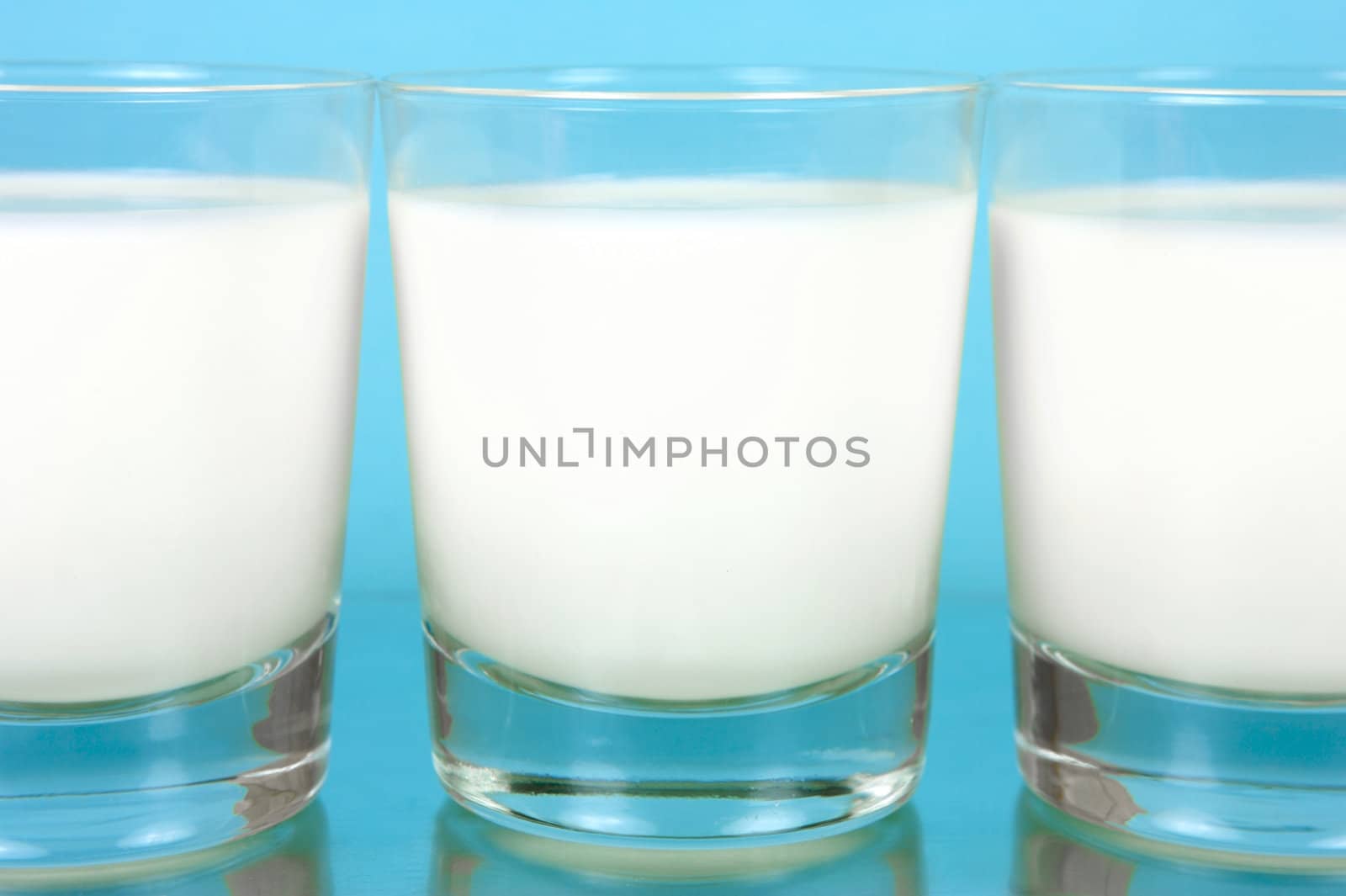 A glass of milk isolated against a blue background