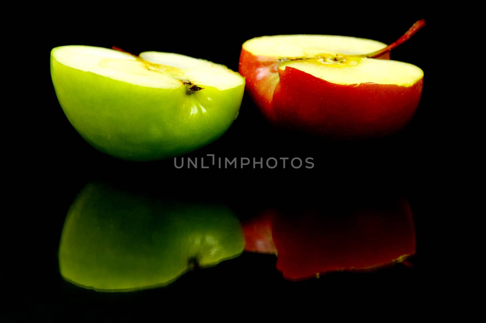 Red and green apples isolated against a black background