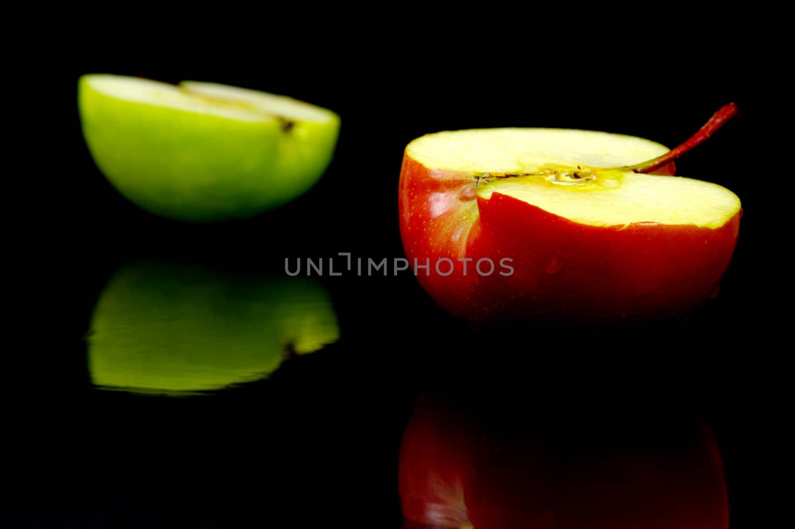 Red and green apples isolated against a black background