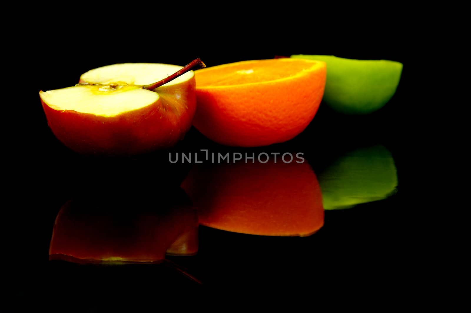 Apple and oranges isolated against a black background