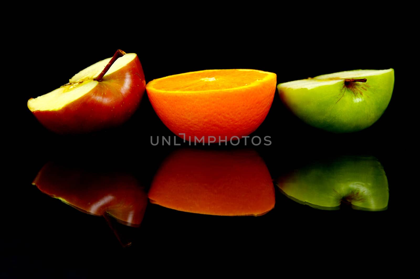 Apple and oranges isolated against a black background