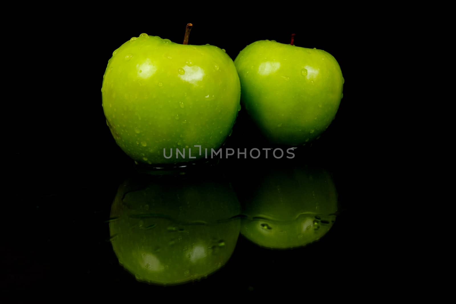 Green Apples isolated against a black background