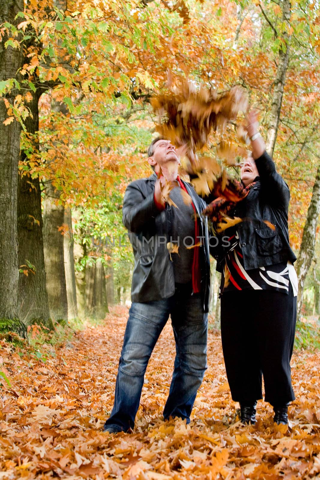 Older couple tossing leafs by DNFStyle