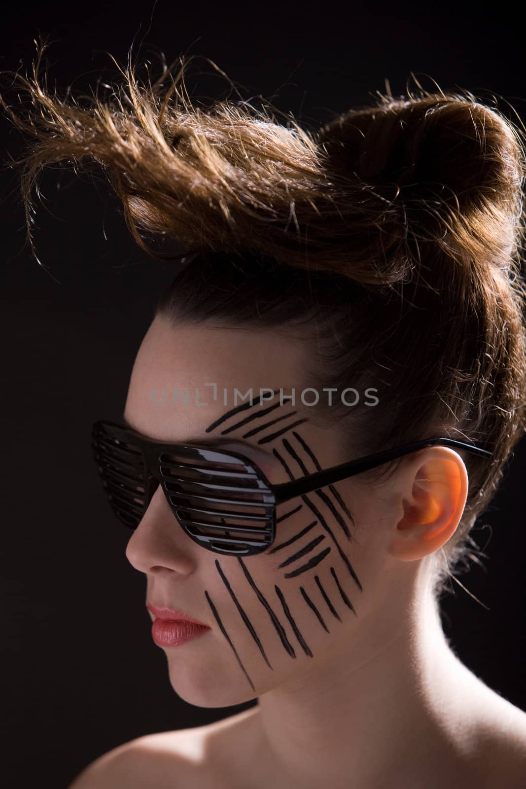 Beautiful woman with wild hairstyle and striped makeup