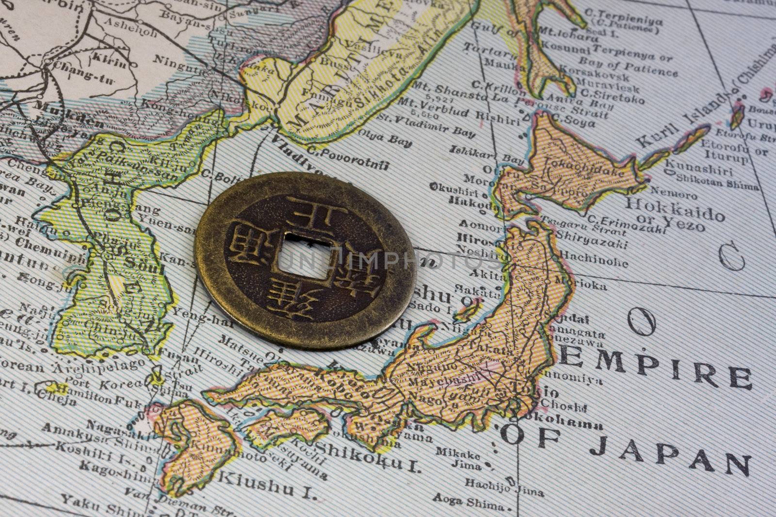 Empire of Japan on a vintage map (1926) and old Japanese coin with square hole