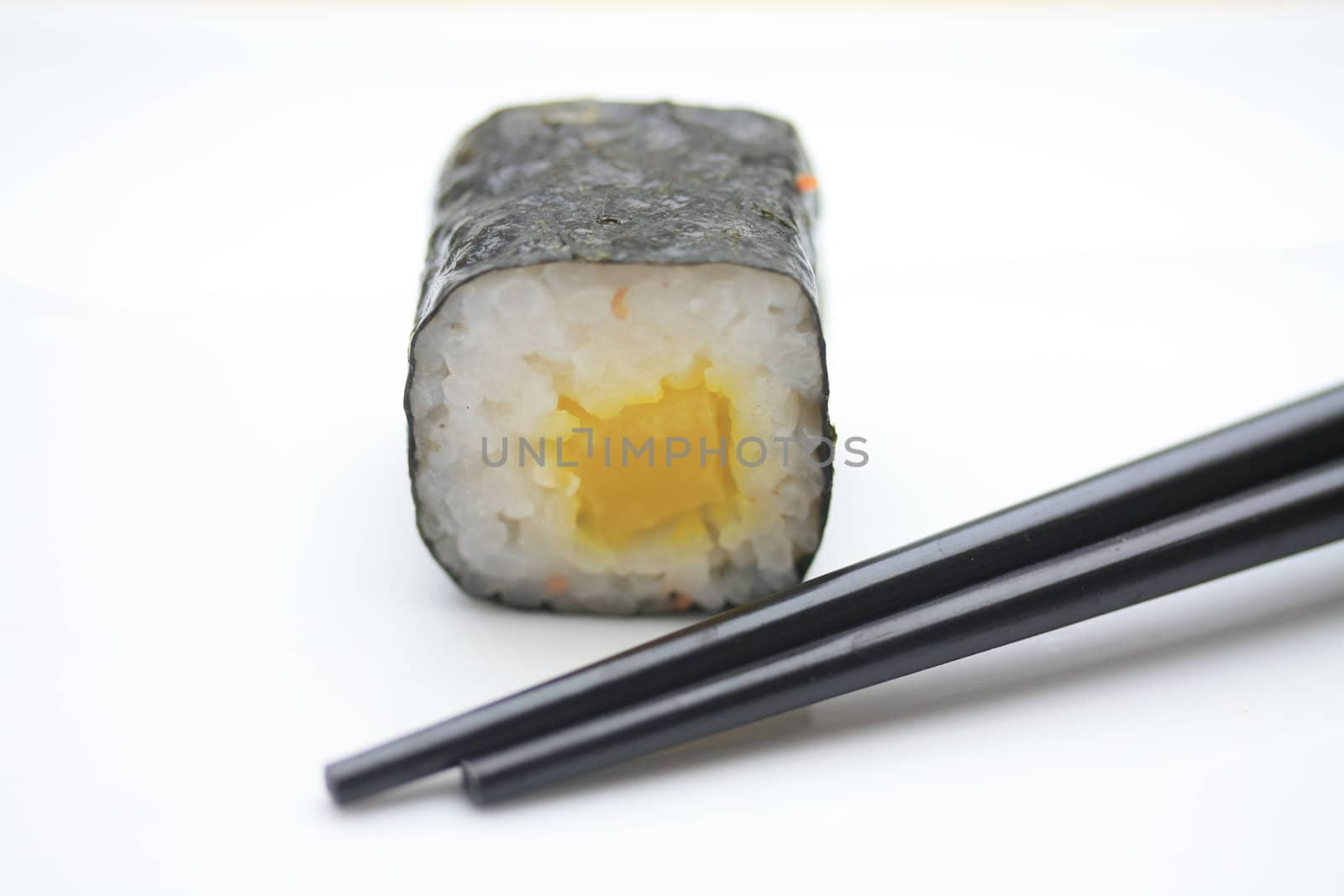 A piece of makisushi, rice rolled in seaweed and chopsticks