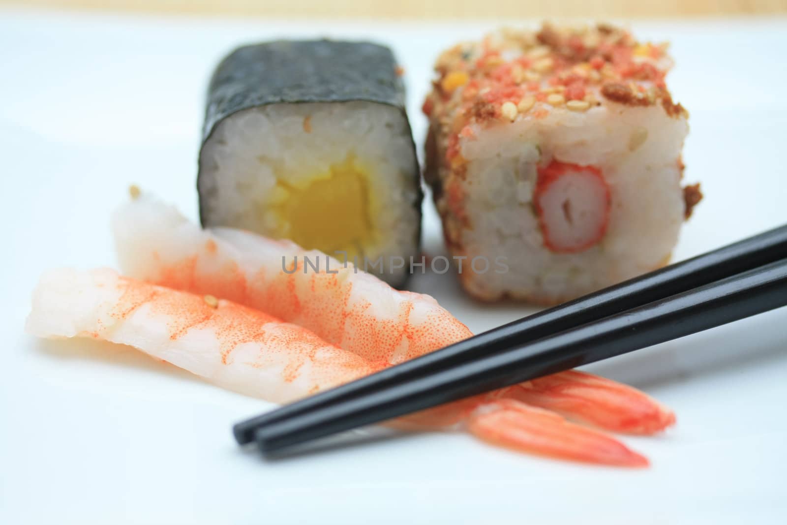 Two pieces of sushi� sesame and rice and a traditional Makisushi, made from rice rolled in seaweed called Nori. 
