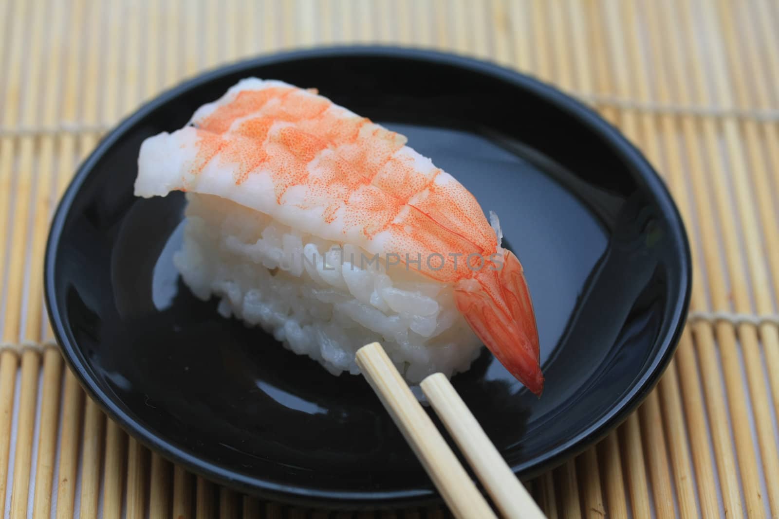 A piece of nigirisushi, rice with a scrimp topping