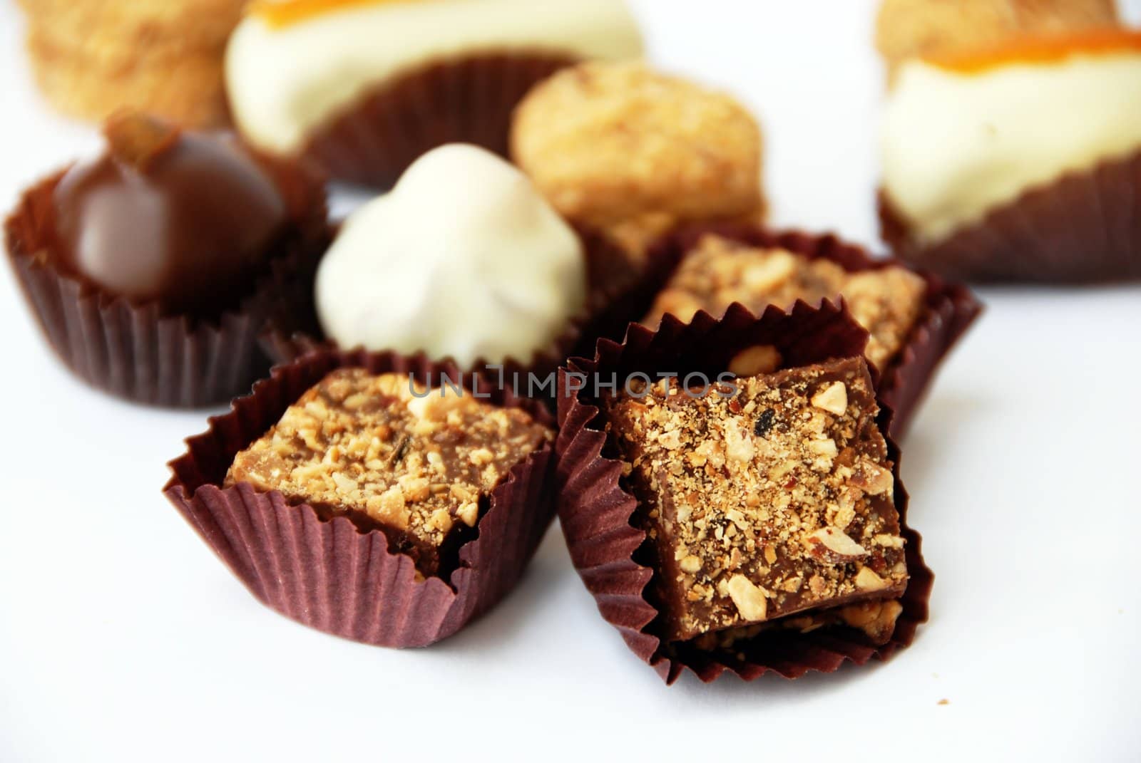 various sweet appetizing cookies in paper cups on white background