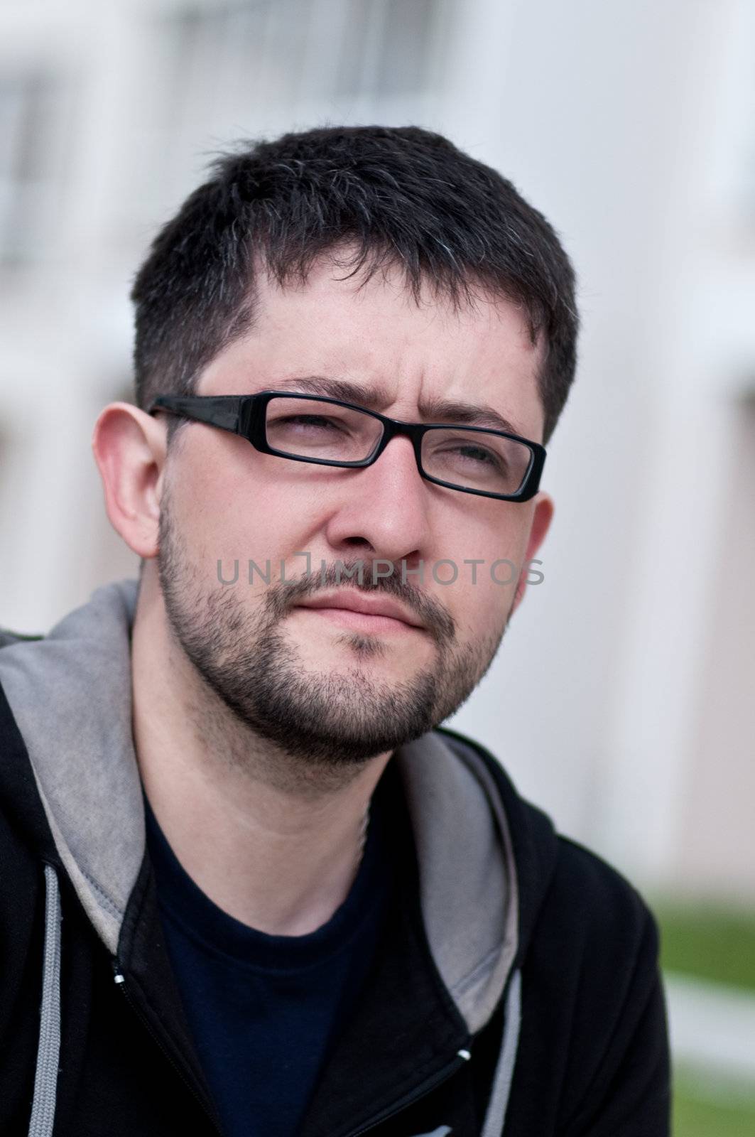 Portrait of a young male caucasian student with beard and glasses