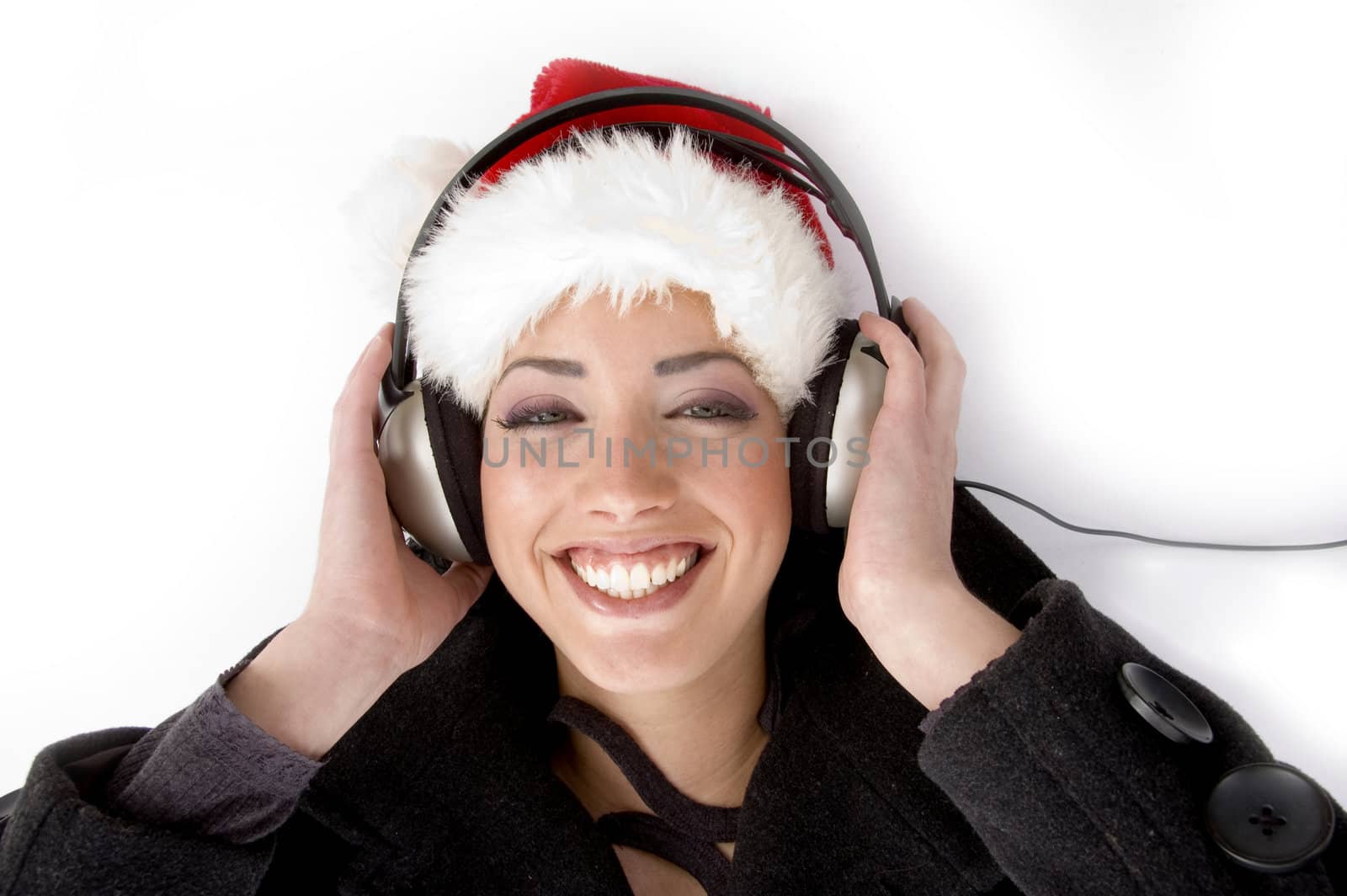 happy female listening music and wearing christmas hat against white background