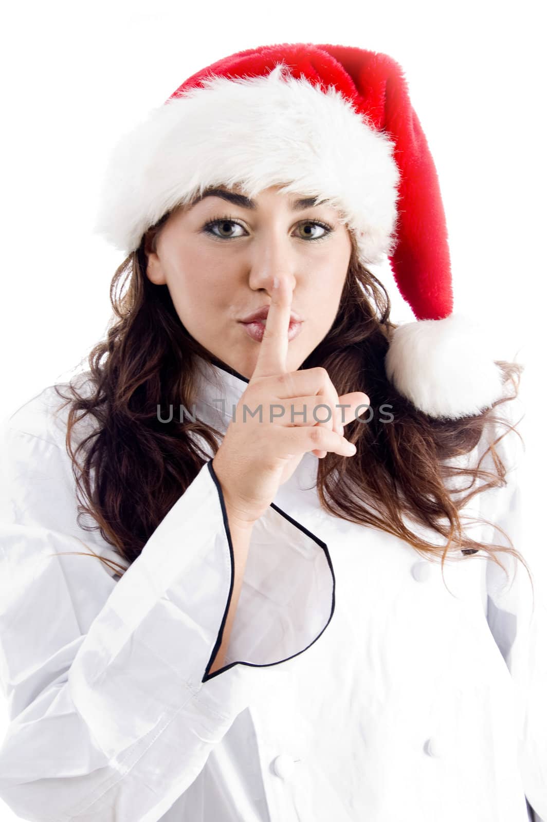 pretty chef wearing christmas hat and shushing with finger on an isolated background