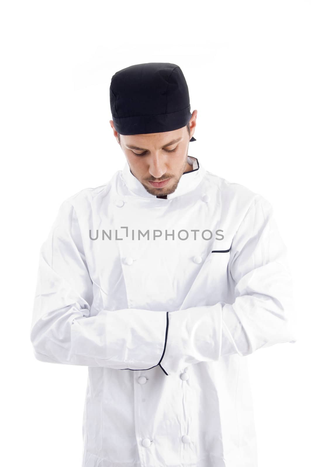 pleased caucasian chef looking downwards with white background