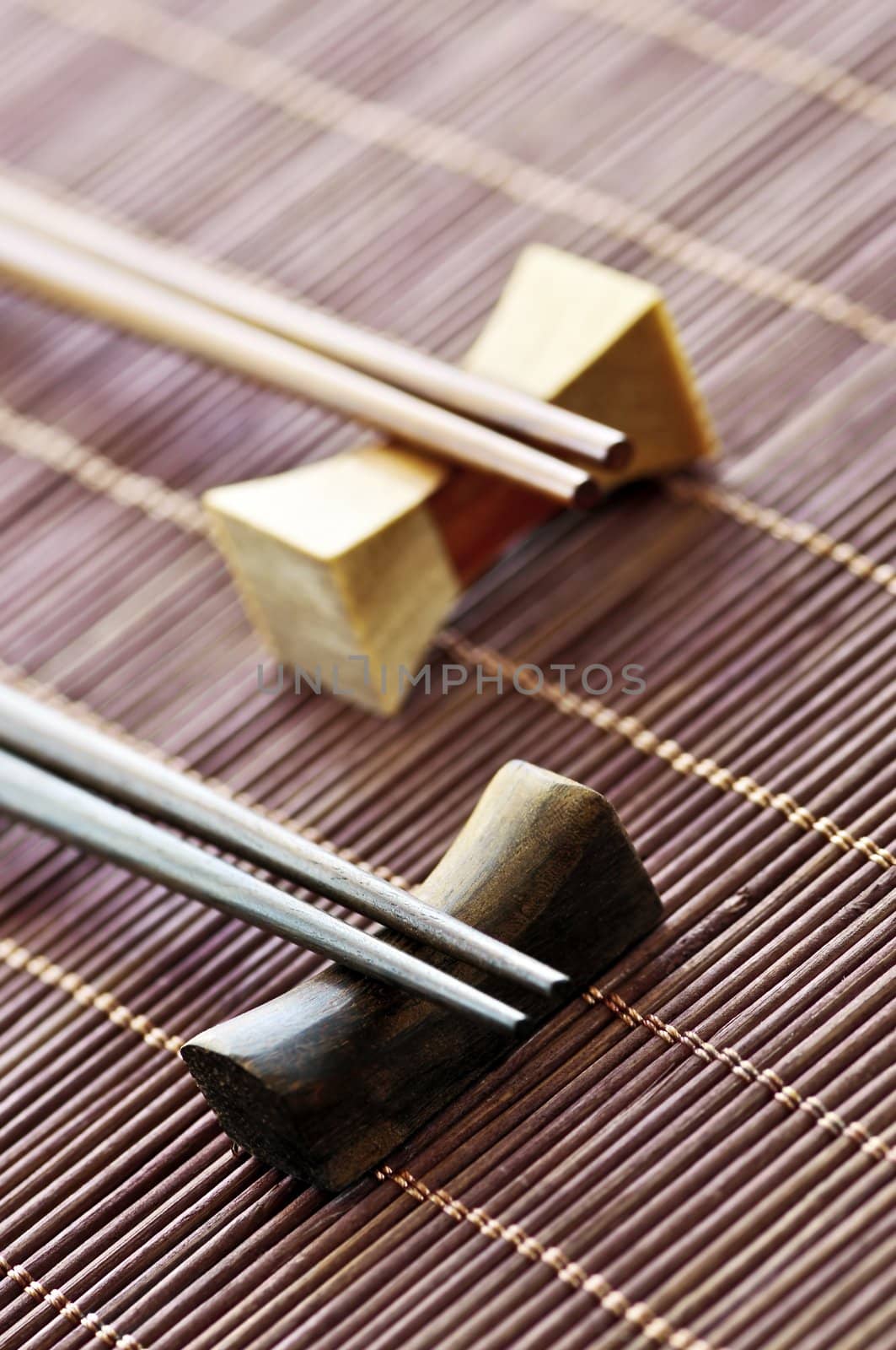 Two sets of wooden chopsticks on rests close up