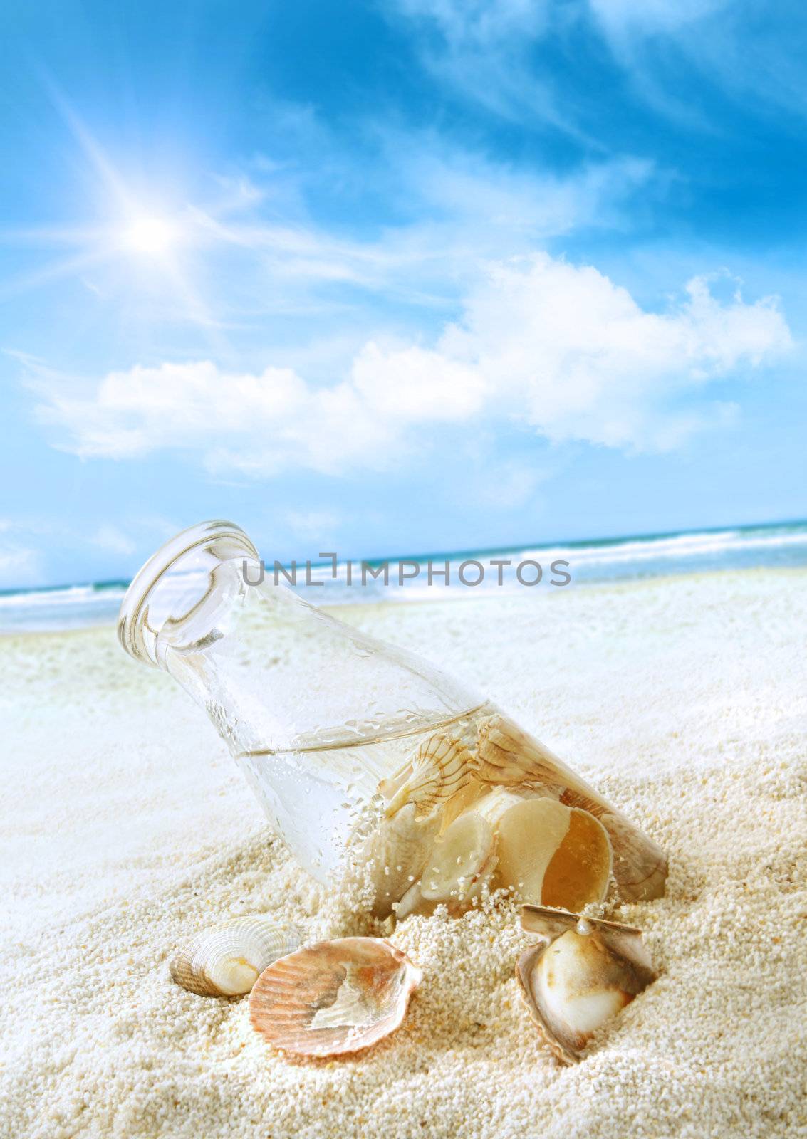 Bottle with seashells in the sand  by Sandralise