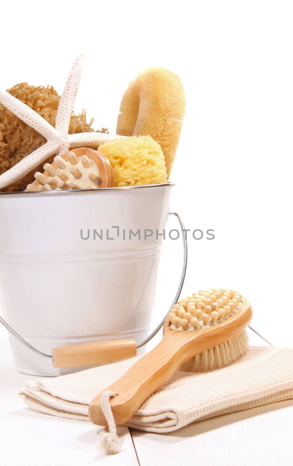 Bucket filled with sponges, scrub brushes and starfish  by Sandralise