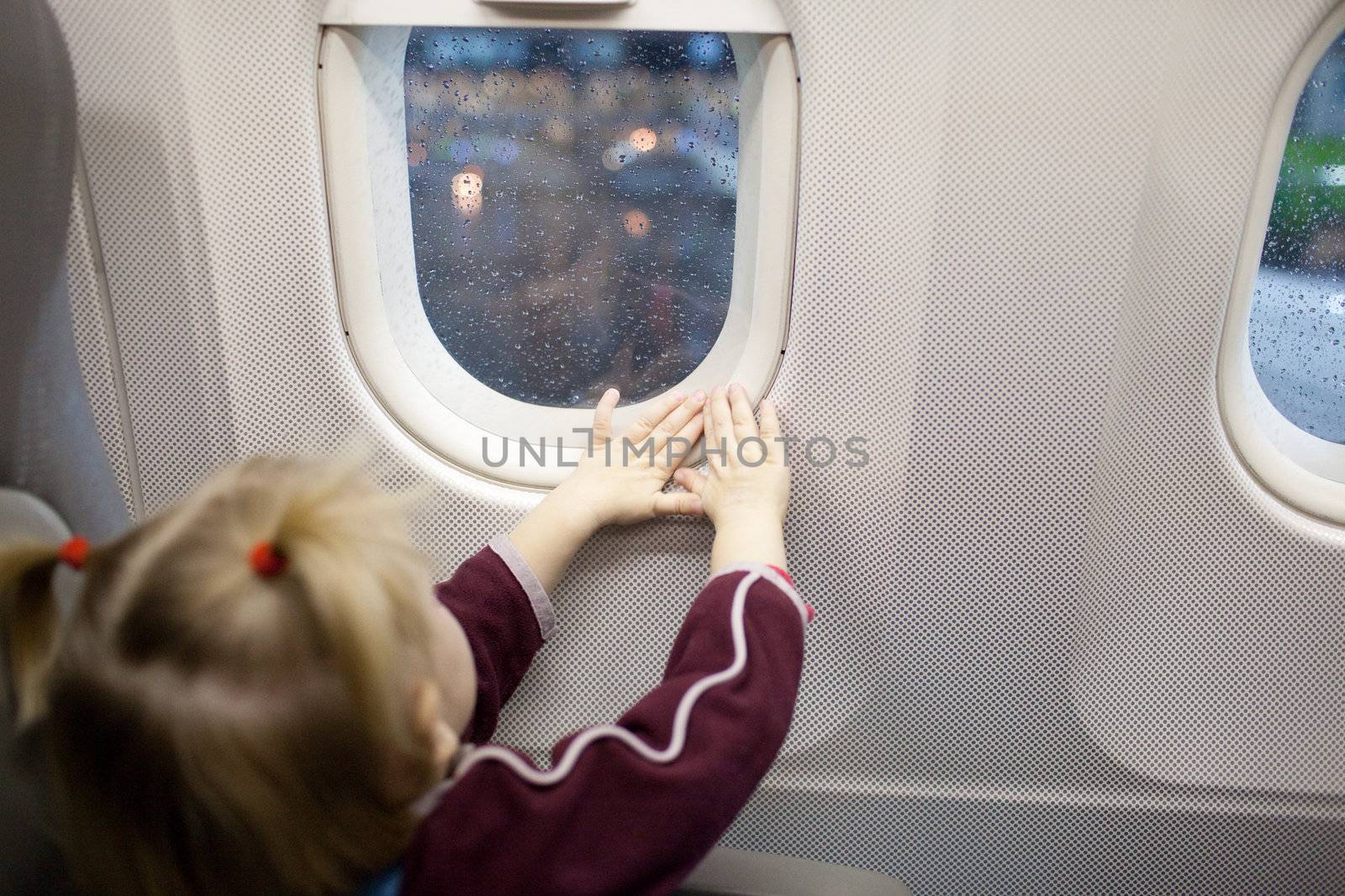 hands of child in the window of airplane by vsurkov