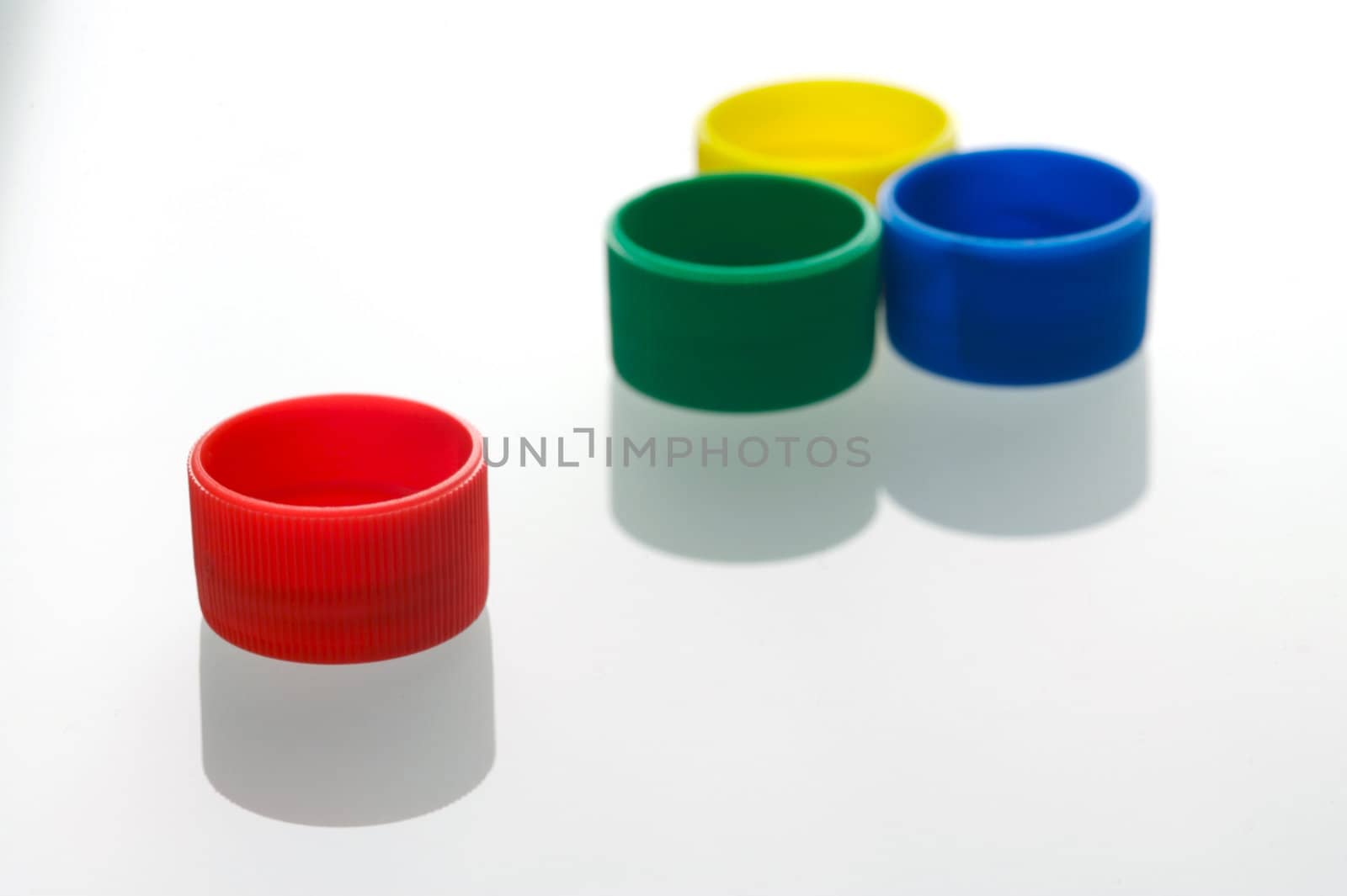 Coloured bottle tops isolated against a white background