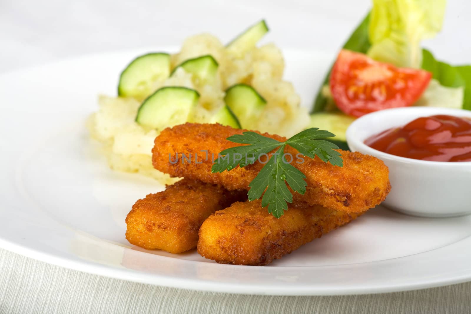 three fish fingers and potatoe salad