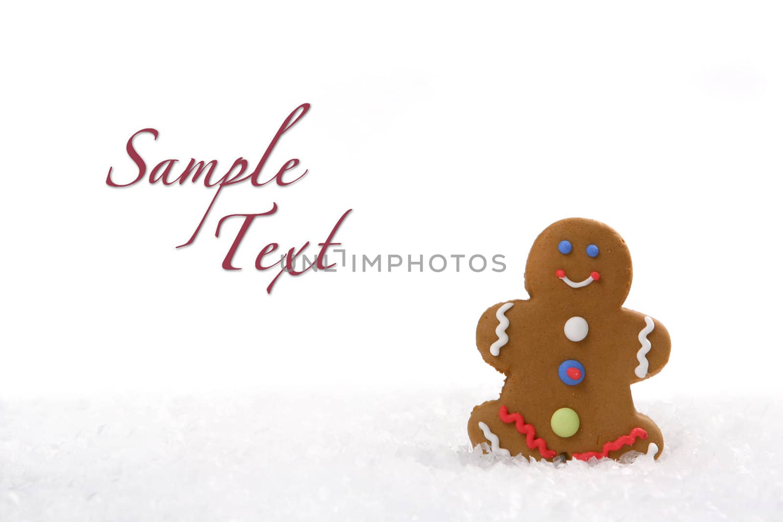 One Gingerbread Man Sitting in the Snow on White Background With Copyspace