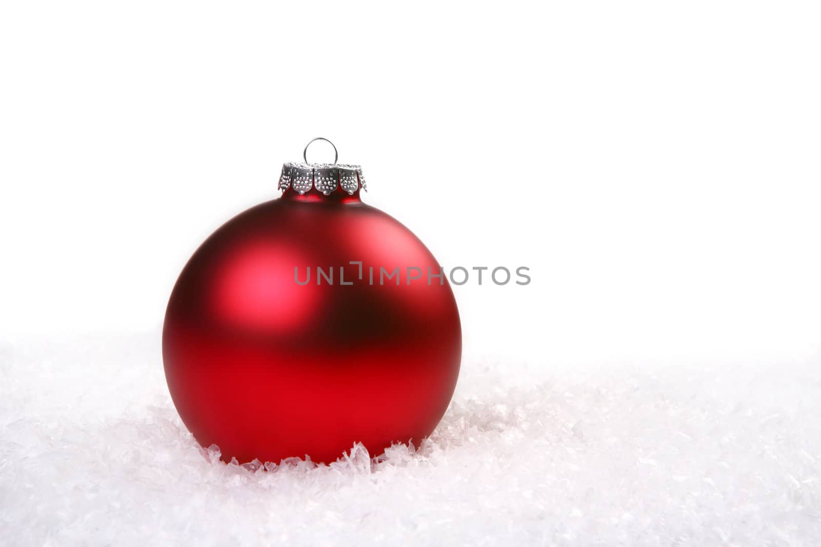 Single Red Shiny Christmas Ornament in the Snow With Copyspace