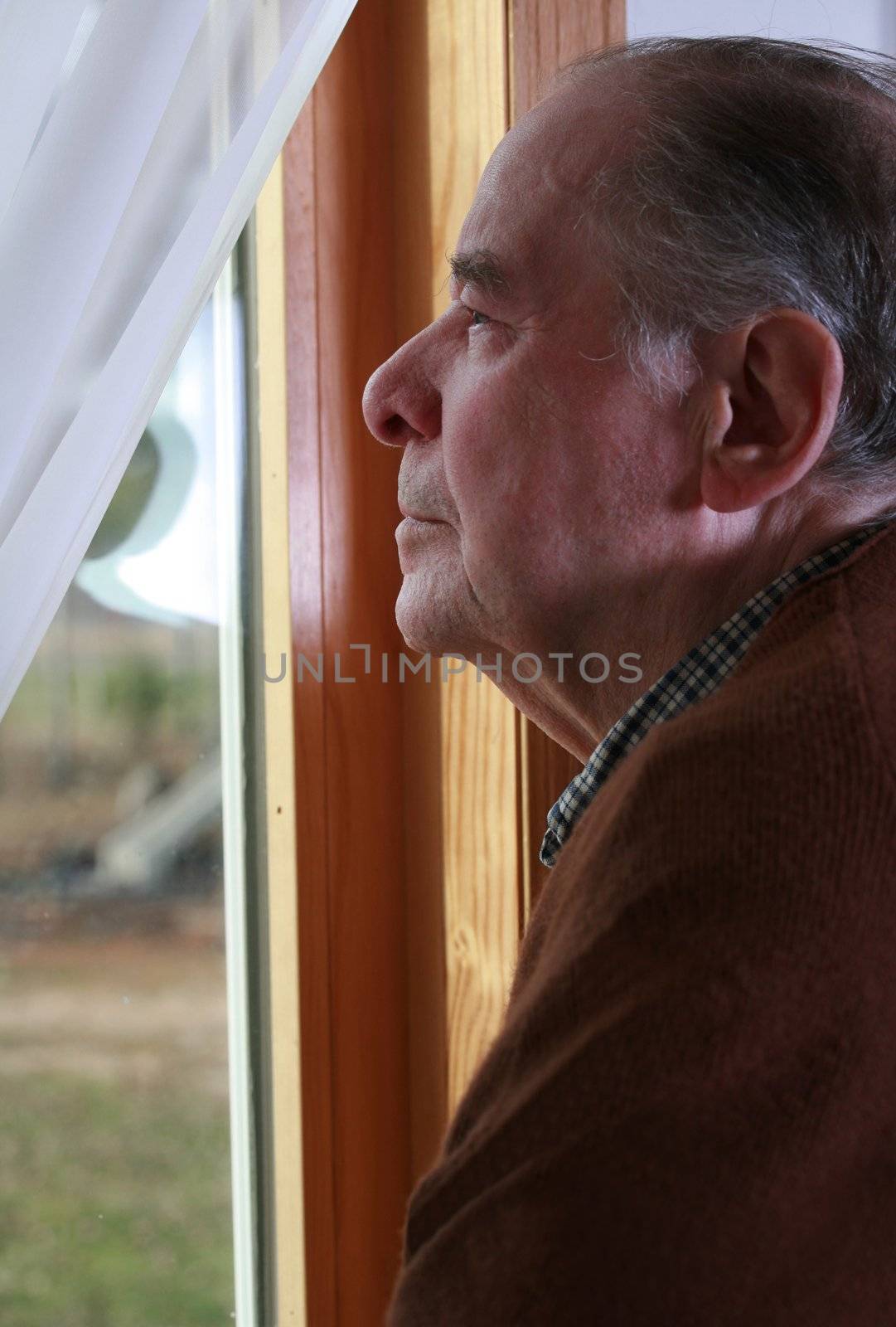 Elderly man looking out window