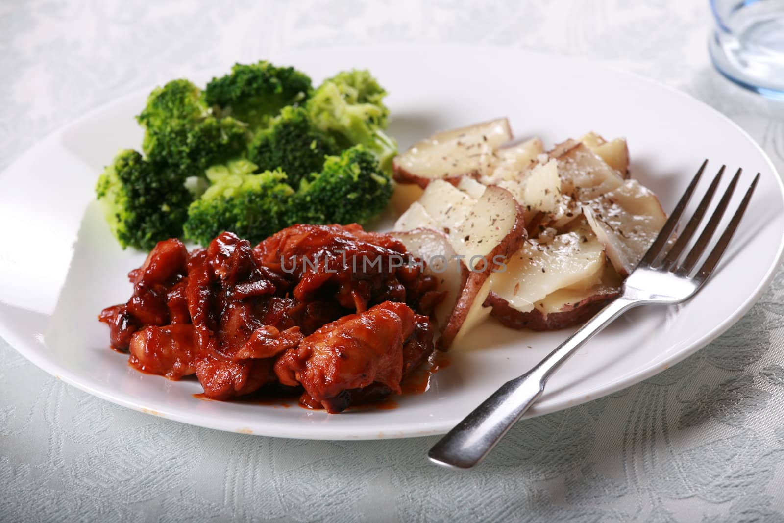 Delicious barbecue chicken meal with side of broccoli and potatoes