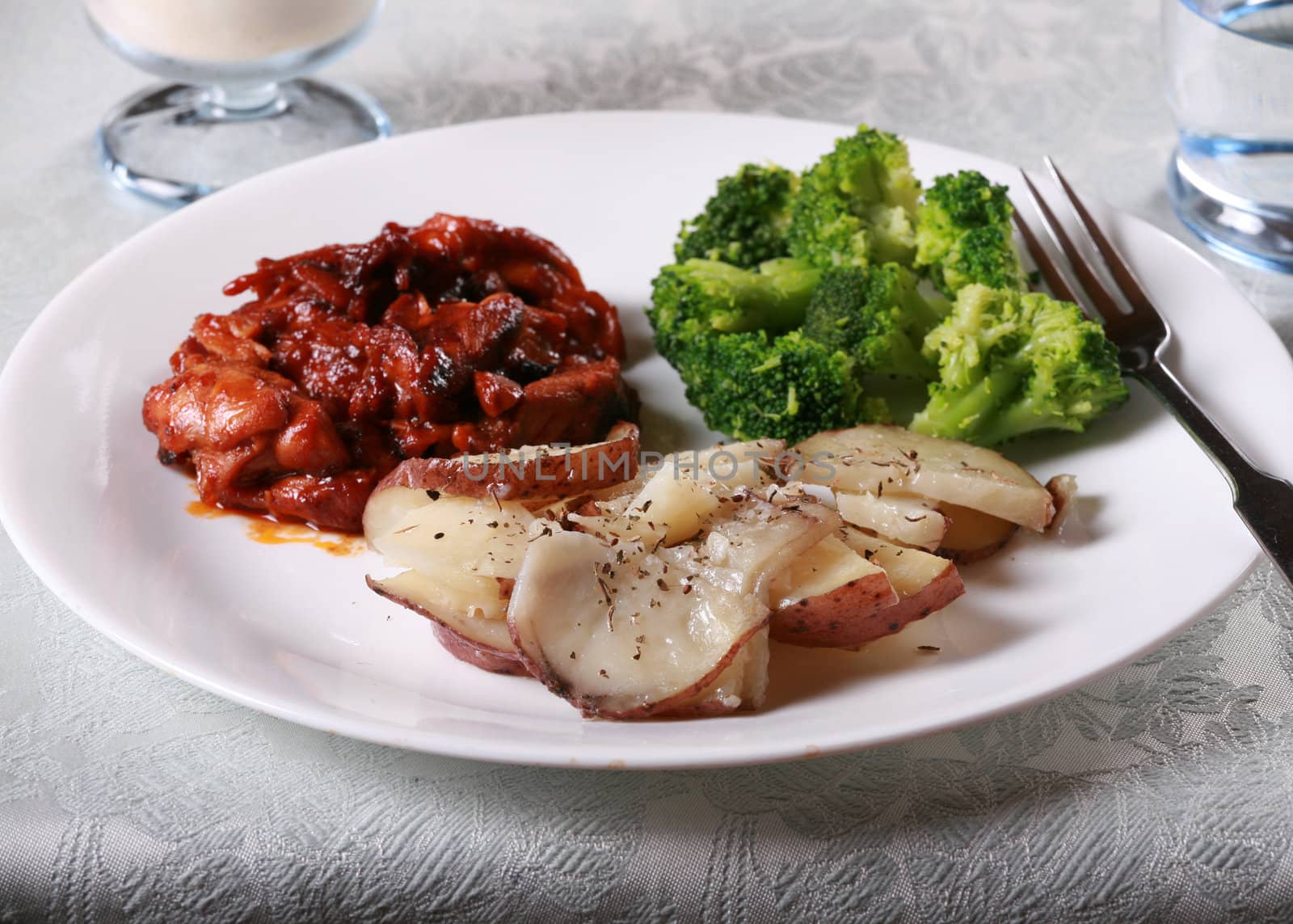 Delicious barbecue chicken meal with side of broccoli and potatoes