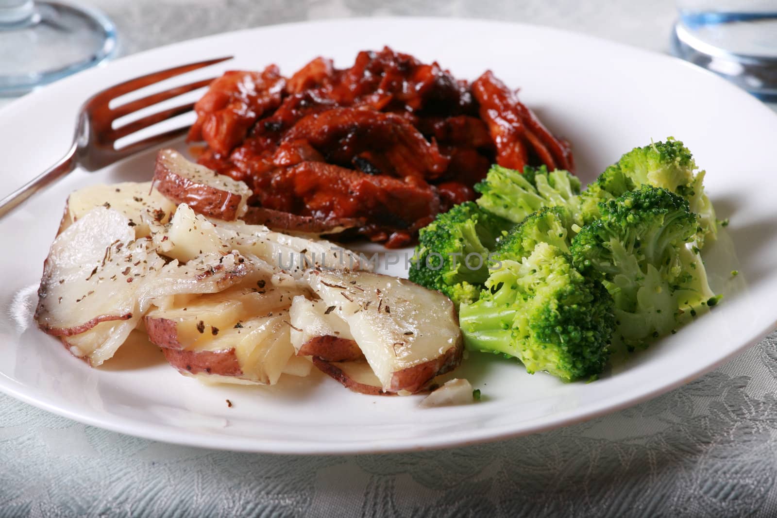 Delicious barbecue chicken meal with side of broccoli and potatoes