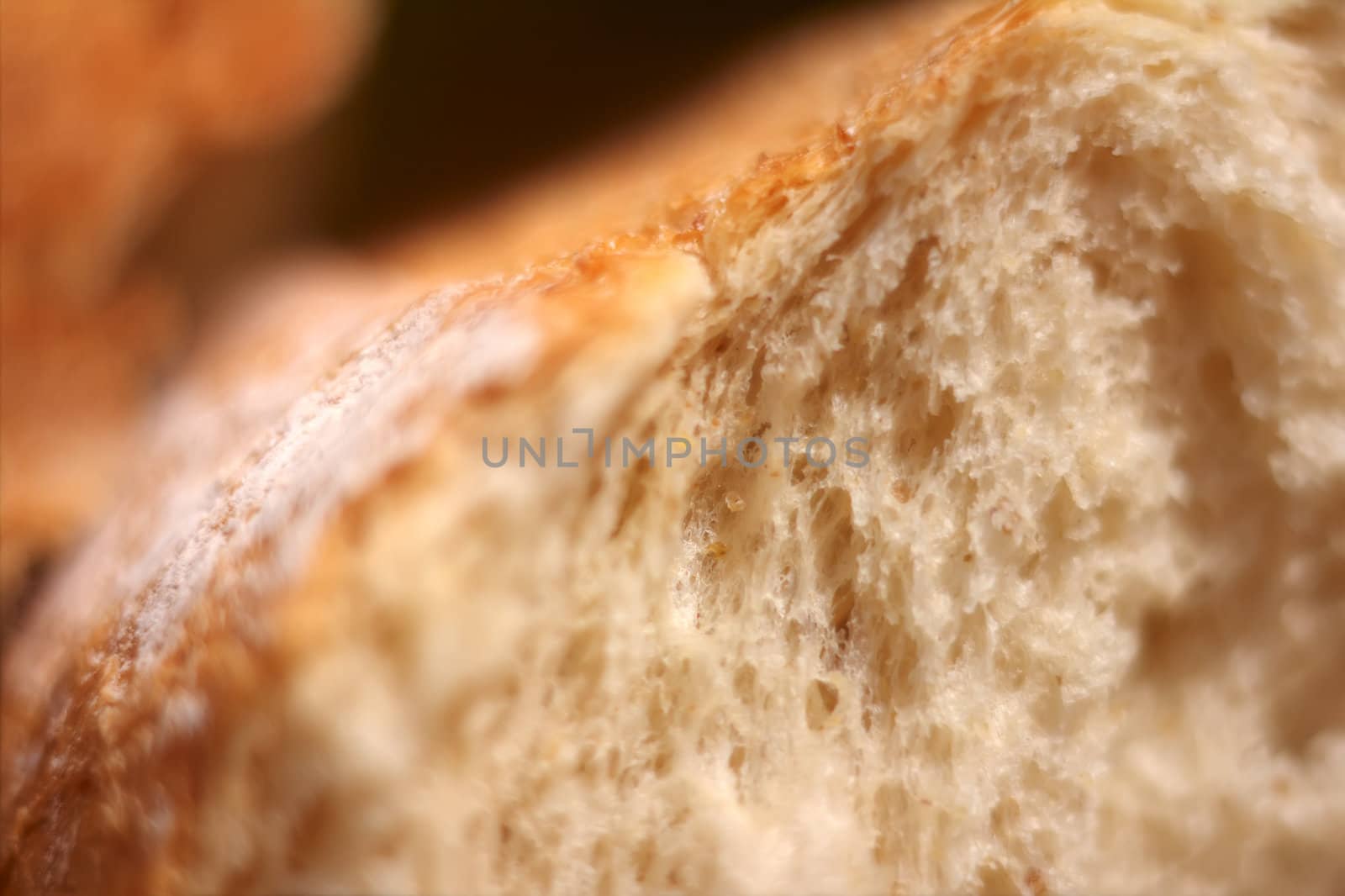 Macro of fresh bread, broken in halves.