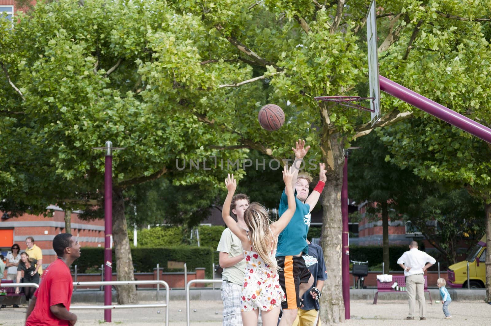 Guys are playing basket on a cement field