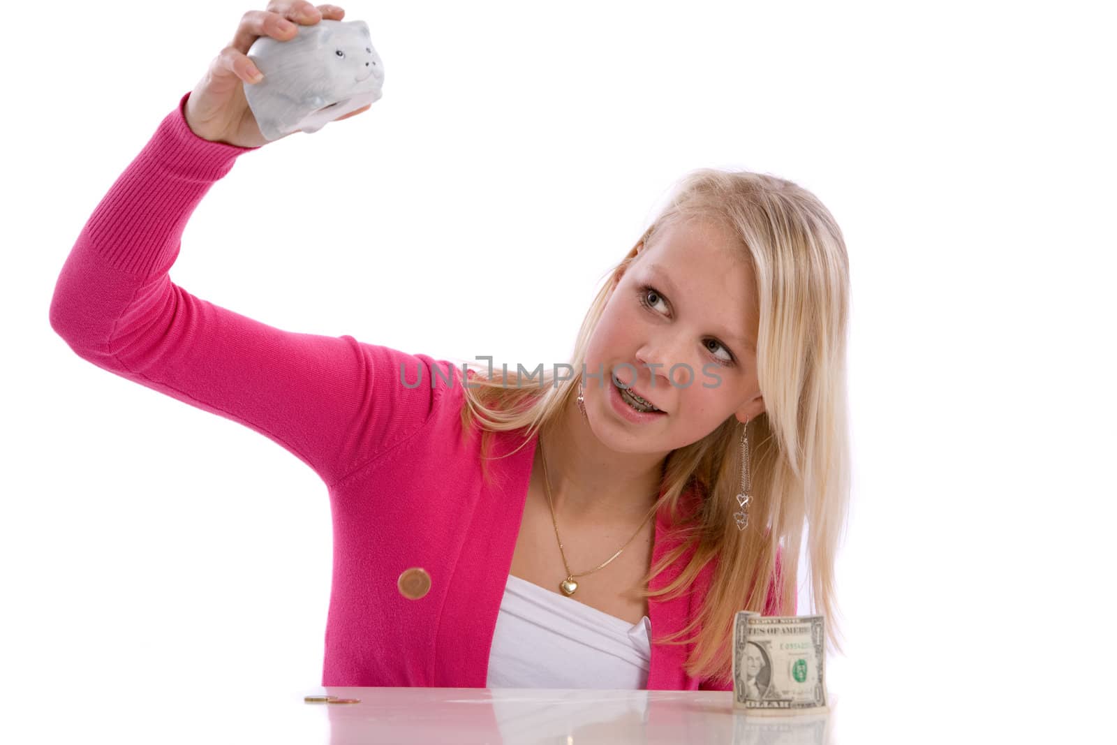 Young cute teenage girl checking the contents of her piggybank