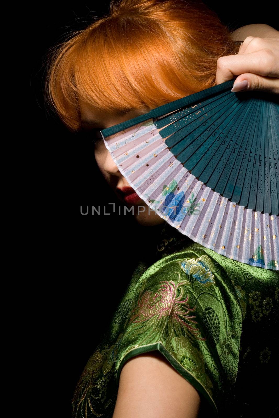 redhead girl in chinese dress playing with fan