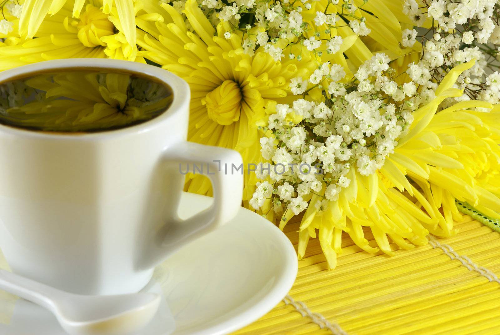 morning cup of coffee with flowers on the table. Shallow DOF