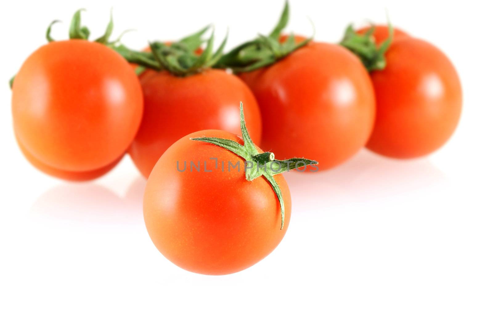 fresh juicy small tomato with a few over white